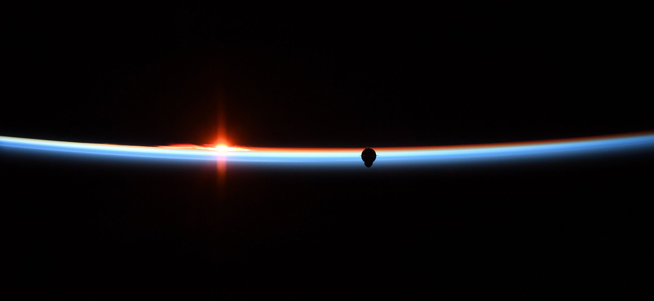 Dragon silhouetted against Earth's limb at sunrise